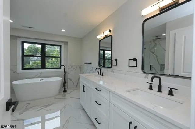 a bathroom with a tub sink and mirror