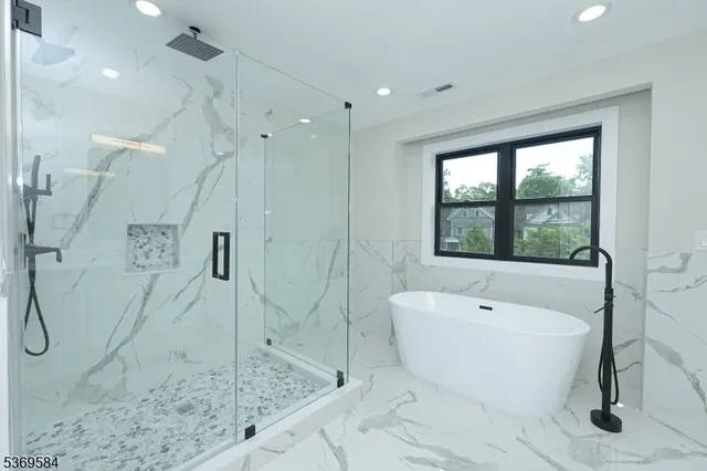 a white bath tub sitting next to a shower