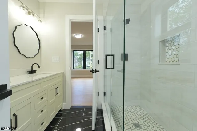 a spacious bathroom with a mirror a sink and a mirror