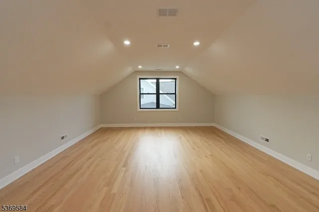 an empty room with wooden floor and window
