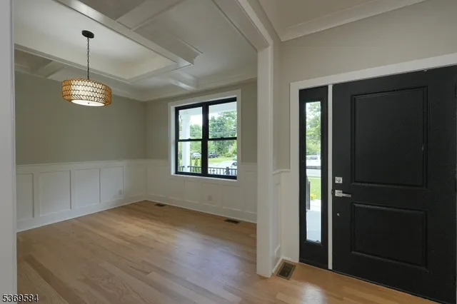 an empty room with wooden floor closet and windows