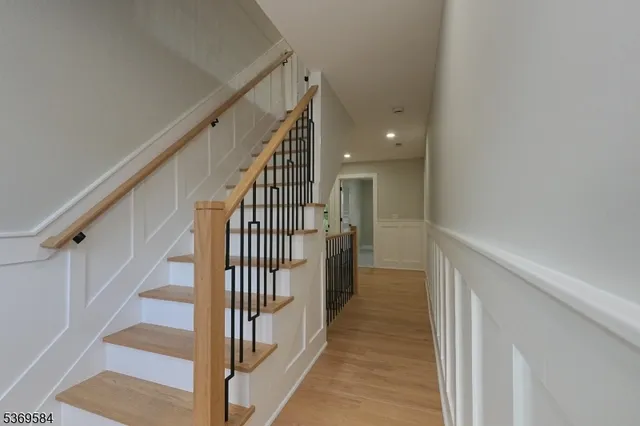 a view of staircase with wooden floor and white walls