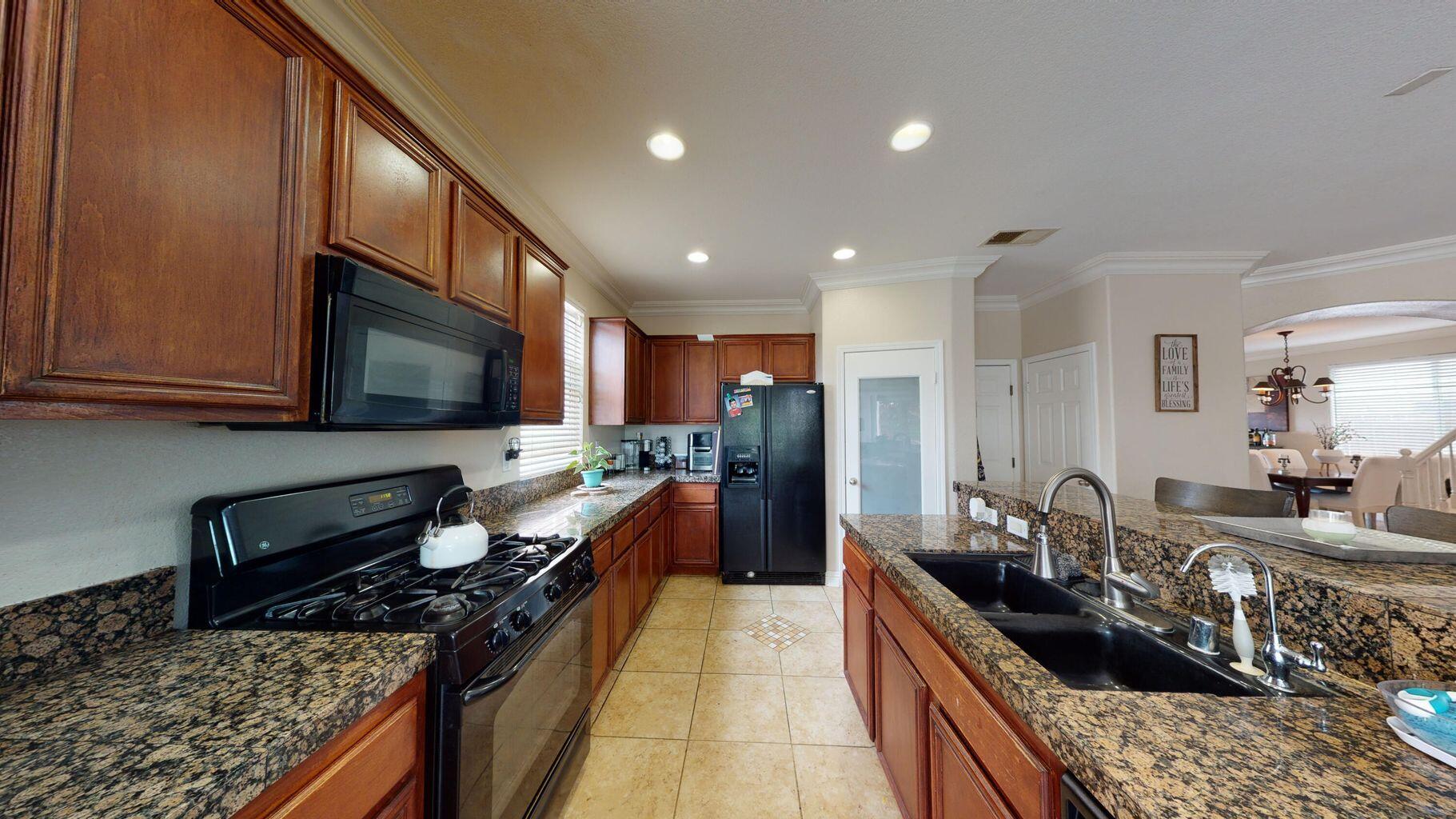 83680 Glendora Ridge Avenue Coachella, CA 92236 - Photo 6 of 32 a kitchen with a stove a sink and a microwave