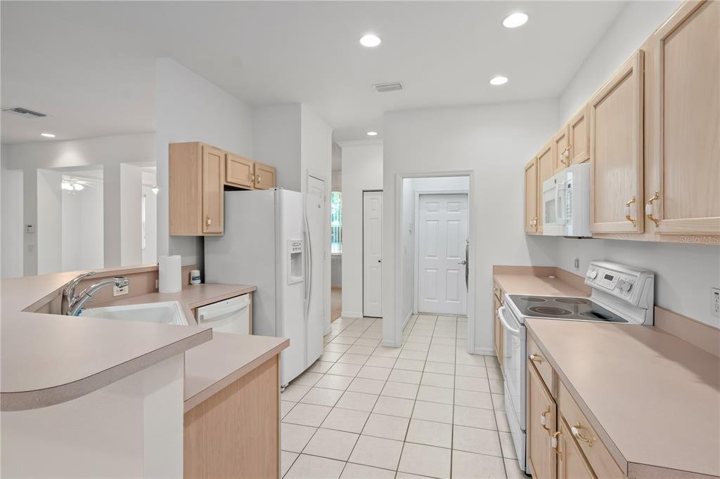 9441 Southwest 90th Street Ocala, FL 34481 - Photo 16 of 48 a kitchen with a sink a refrigerator a stove and cabinets