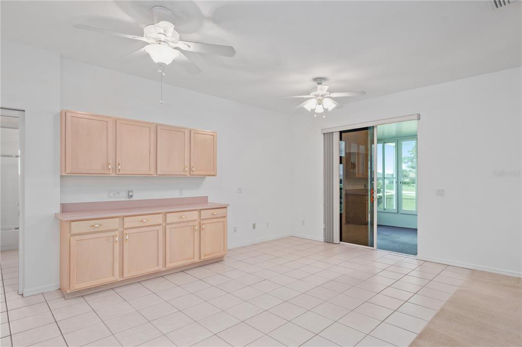 9441 Southwest 90th Street Ocala, FL 34481 - Photo 21 of 48 a view of a kitchen with an oven a ceiling fan and wooden cabinets