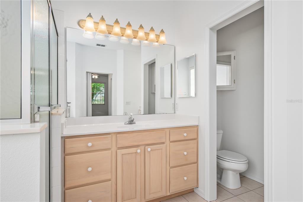 9441 Southwest 90th Street Ocala, FL 34481 - Photo 29 of 48 a bathroom with a granite countertop sink a toilet and a mirror