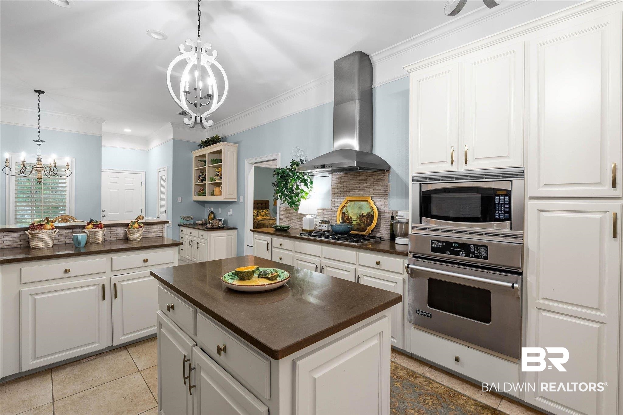 136 Old Mill Road Fairhope, AL 36532 - Photo 6 of 36 Kitchen featuring white cabinetry, a central island with a solid surface countertop, stainless steel appliances, tile flooring, and decorative chandeliers