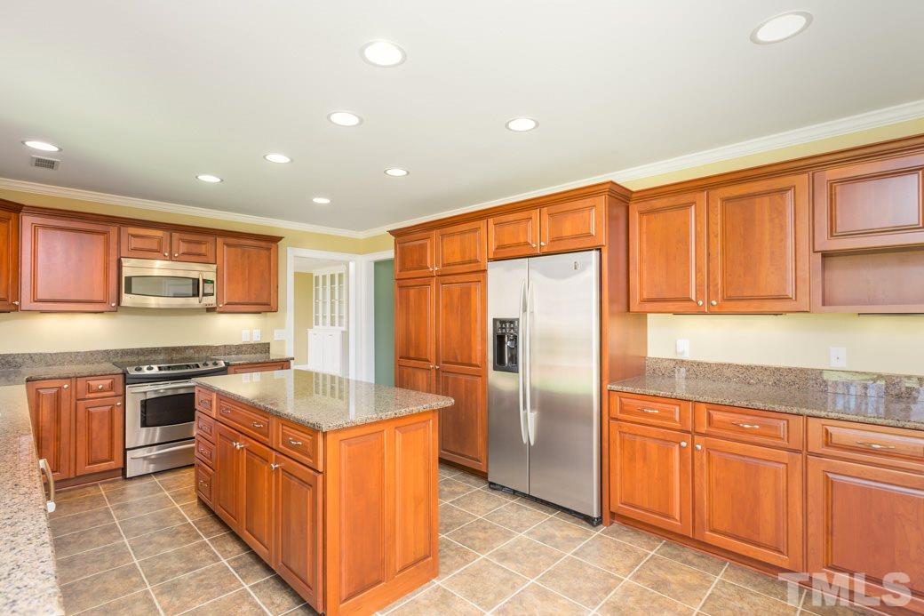 3120 Mt Vernon Church Road Raleigh, NC 27613 - Photo 1 of 9 a large kitchen with stainless steel appliances granite countertop a stove top oven a sink dishwasher and a refrigerator with wooden cabinets