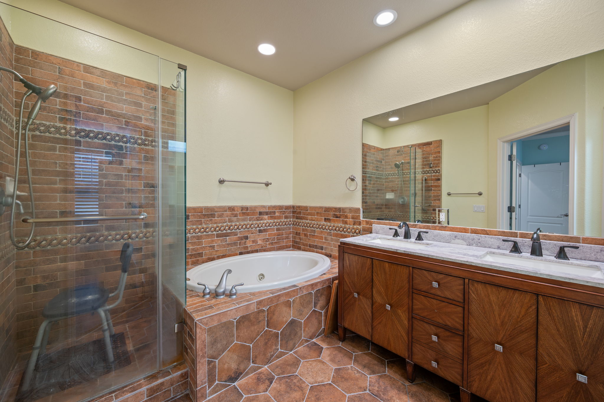 4229 John's Light Drive Austin, TX 78727 - Photo 14 of 27 a bathroom with a tub sink shower and mirror