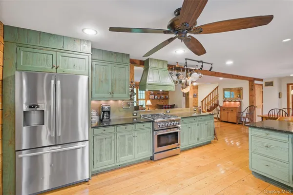 a kitchen with stainless steel appliances granite countertop a refrigerator a sink and a stove
