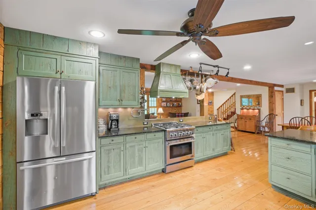 a kitchen with stainless steel appliances granite countertop a refrigerator a sink and a stove