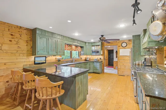 a large kitchen with stainless steel appliances kitchen island granite countertop a sink and cabinets