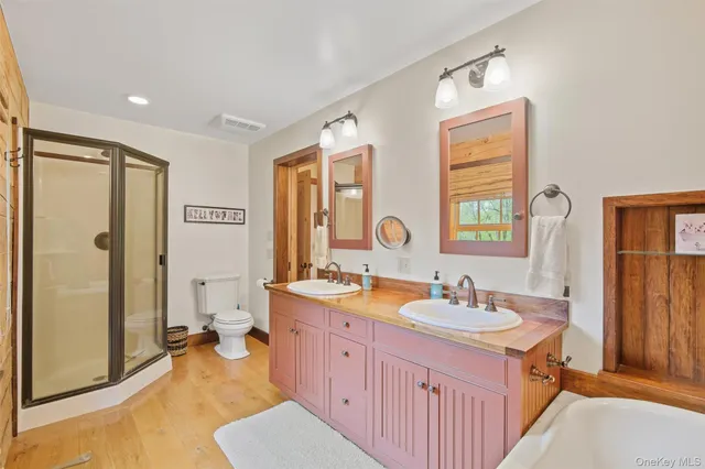 a spacious bathroom with a double vanity sink a mirror and a shower