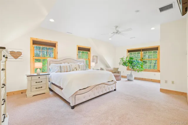 a spacious bedroom with a bed lamp and a large window