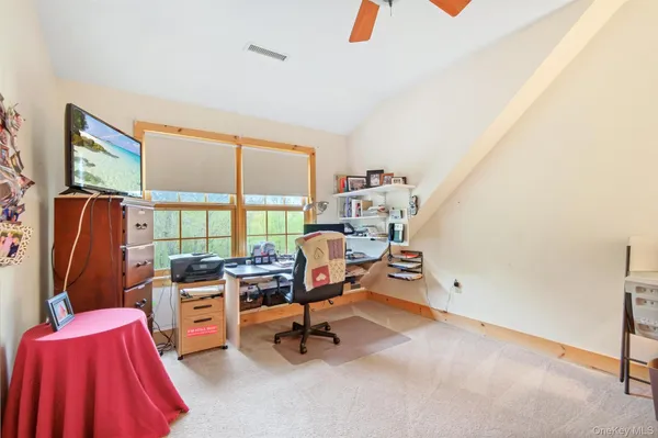 a view of a workspace with furniture and a window