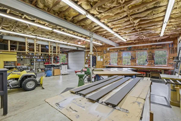 a work room with furniture a rug and a flat screen tv