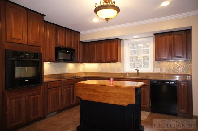 115 Martys Road Boone, NC 28607 - Photo 39 of 43 a kitchen with granite countertop a sink a stove a counter space and cabinets