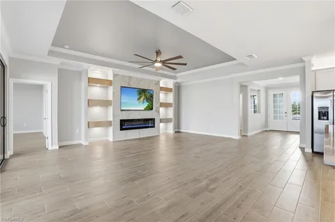 a view of an empty room with window and wooden floor
