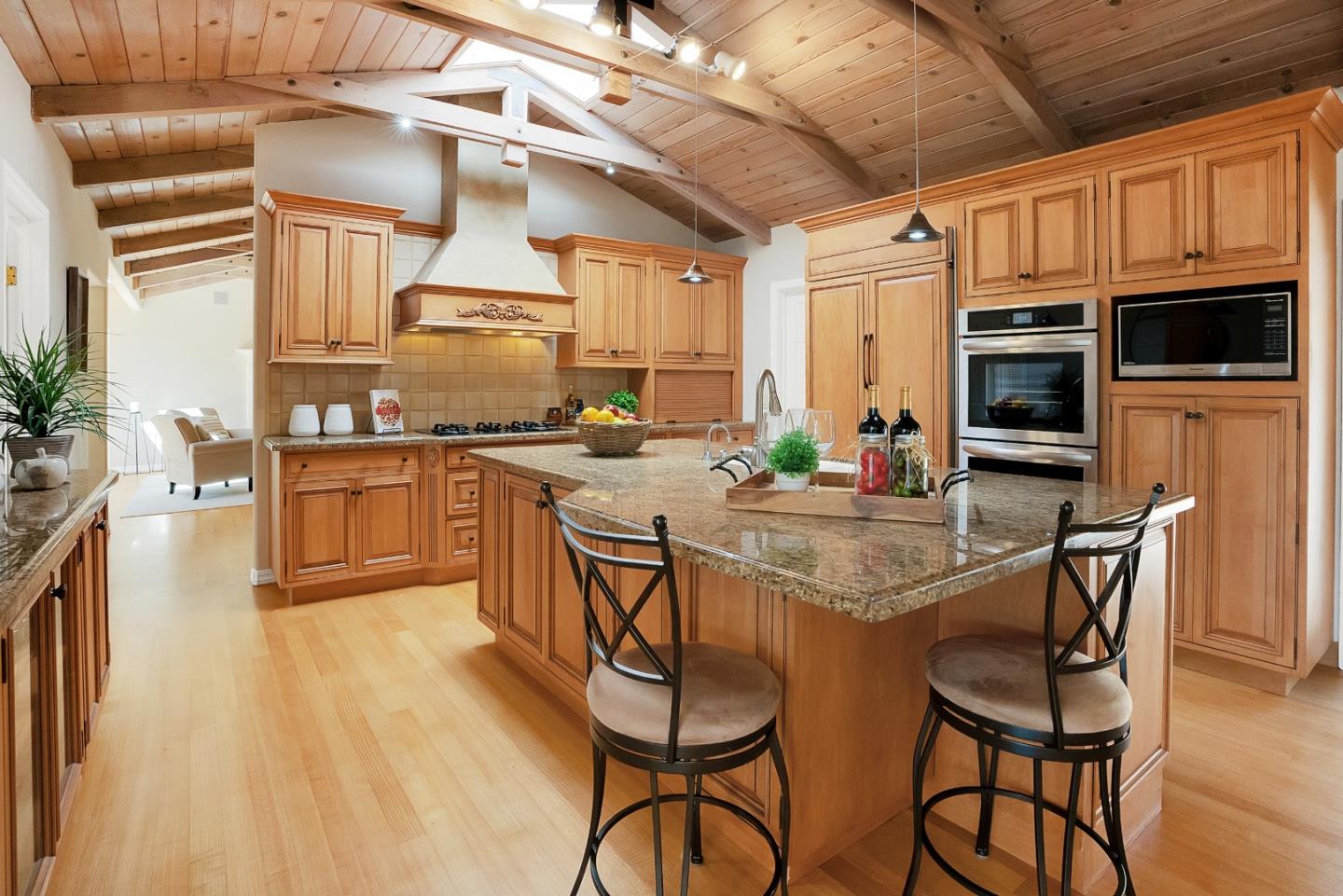 23342 Deerfield Road Los Gatos, CA 95033 - Photo 9 of 36 a kitchen with stainless steel appliances granite countertop a stove a refrigerator a kitchen island a dining table and chairs with wooden floor