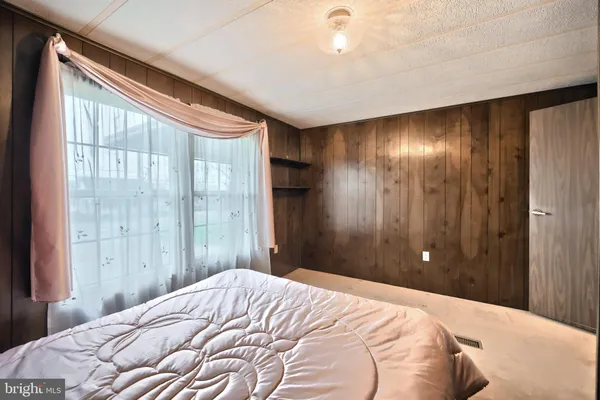 a bedroom with a bed and a large window
