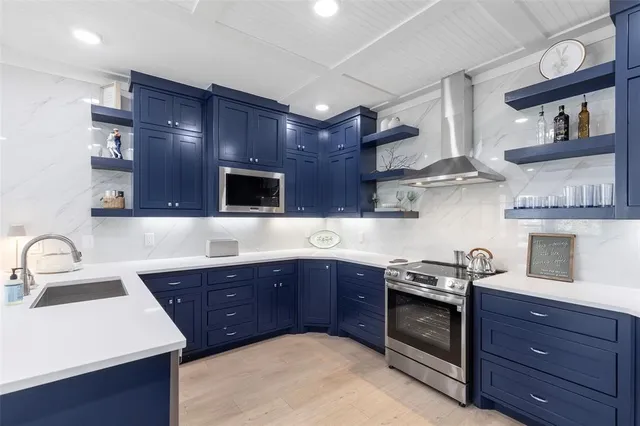 a kitchen with stainless steel appliances sink a stove and cabinets