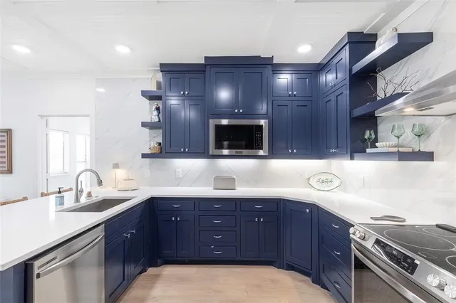 a kitchen with a sink and a stove with wooden cabinets