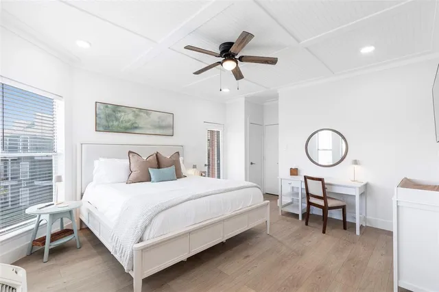 a bedroom with a bed a mirror and a large window