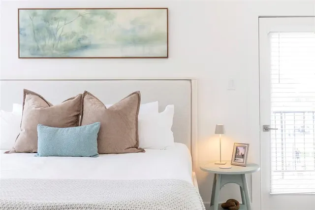 a bed sitting in a bedroom next to a window