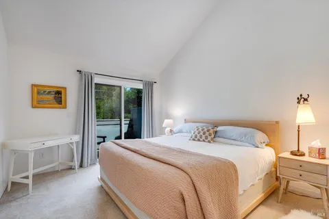 a bedroom with a bed and painting on the wall