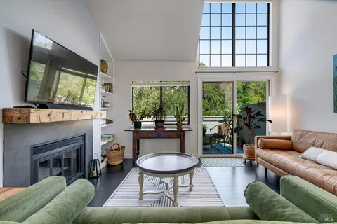 a living room with furniture a large window and a flat screen tv
