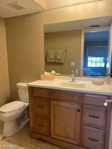 a bathroom with a granite countertop toilet a sink and a mirror