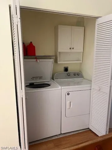 a utility room with wooden floor washer and dryer