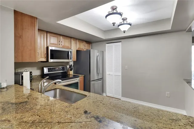 a kitchen with kitchen island a sink stainless steel appliances and a counter top space