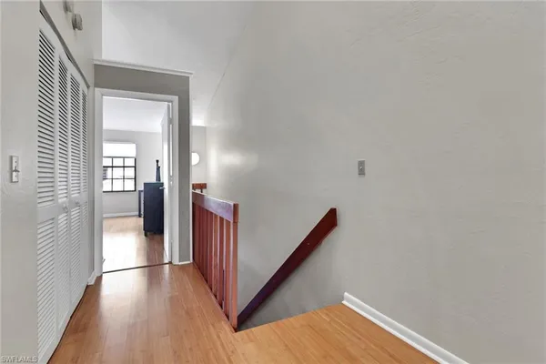 a view of a hallway with wooden floor and staircase