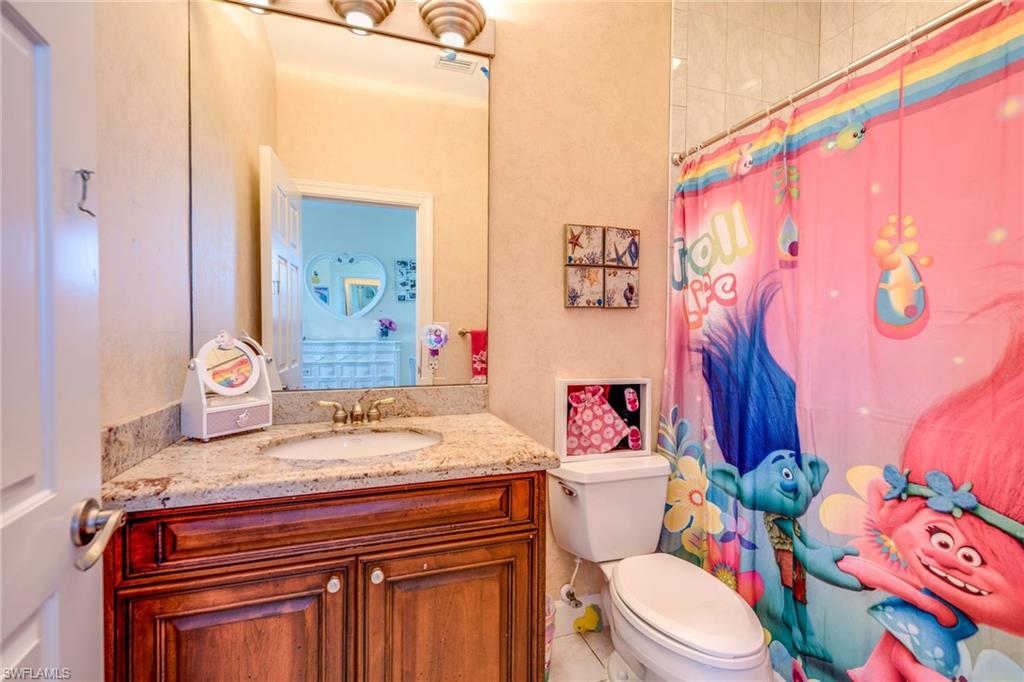 1672 Jewel Naples, FL 34102 - Photo 17 of 27 a bathroom with a sink a toilet and shower curtain