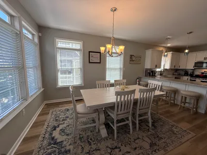 a view of a a dining room with furniture window and wooden floor