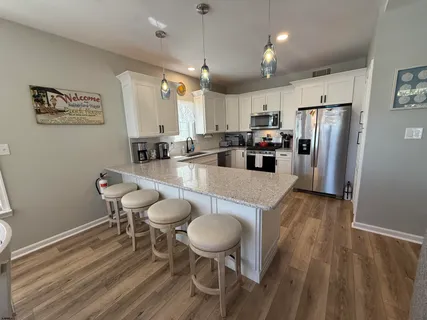 a kitchen with sink refrigerator dining table and chairs
