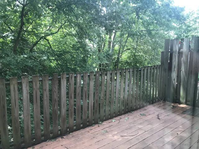 a wooden fence with trees in front of it