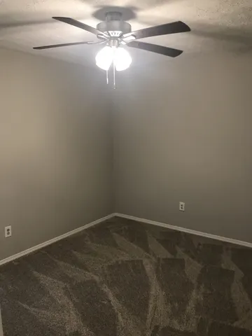 a view of a small space with wooden floor and fan