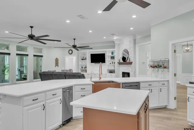 a large white kitchen with cabinets and wooden floor