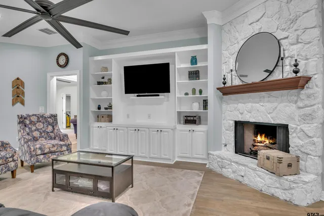 a living room with furniture a flat screen tv and a fireplace