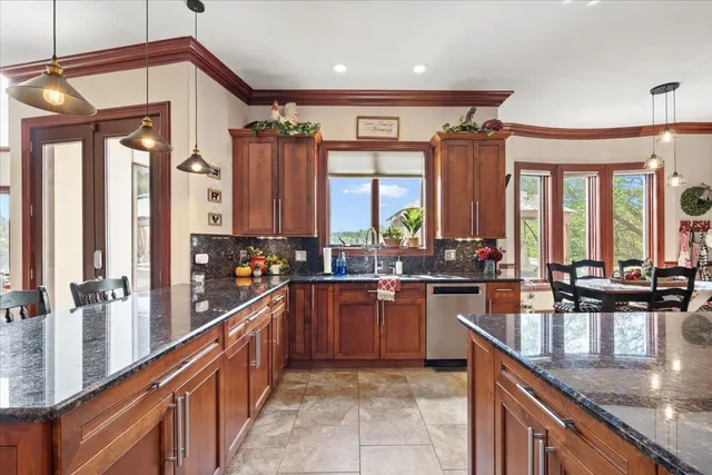 a bathroom with a granite countertop toilet a sink a mirror a shower curtain and a large window