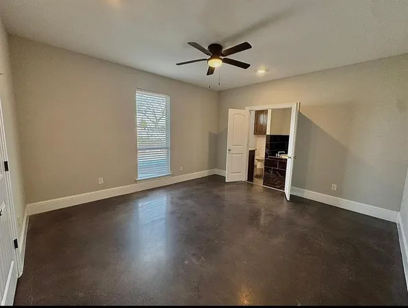 a view of empty room with wooden floor and ceiling fan