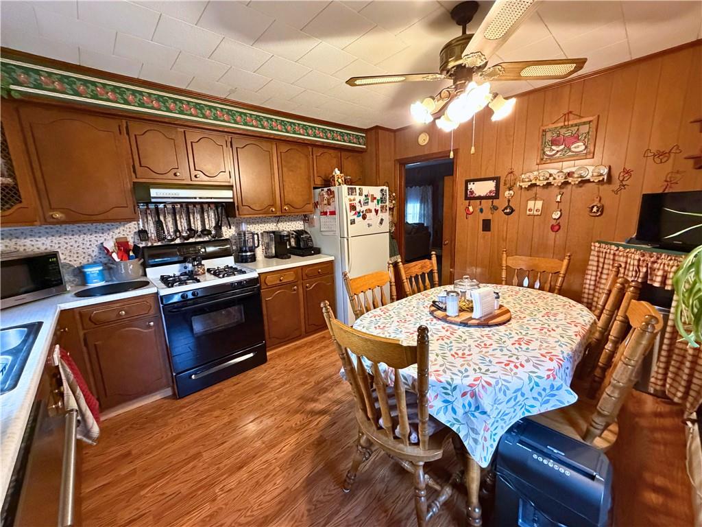 1648 Butler Pike Mercer, PA 16137 - Photo 10 of 25 a kitchen with stainless steel appliances granite countertop a stove a refrigerator a kitchen island a dining table and chairs with wooden floor