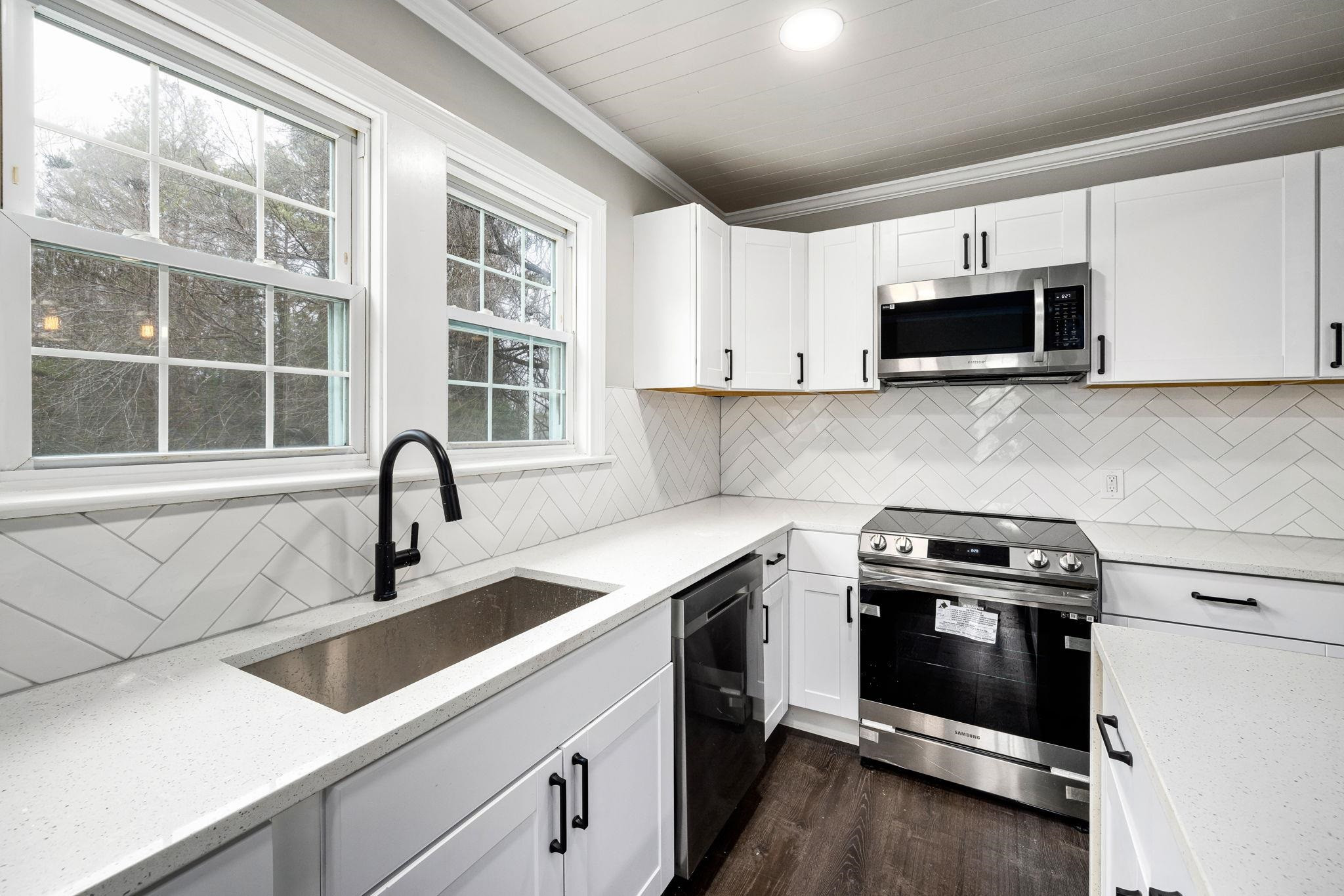 1716 Chapel Hill Road Durham, NC 27707 - Photo 17 of 33 a kitchen with stainless steel appliances a stove a sink a microwave and cabinets