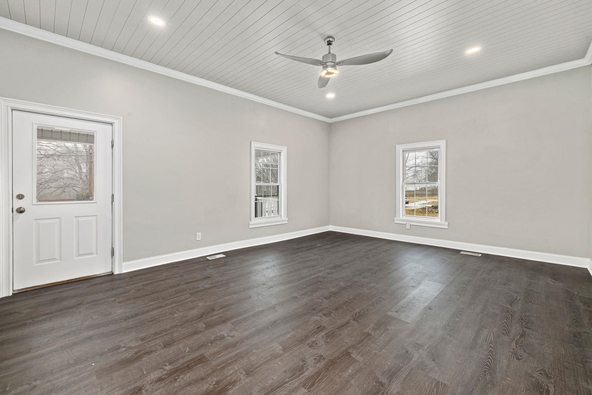 1716 Chapel Hill Road Durham, NC 27707 - Photo 6 of 33 an empty room with wooden floor chandelier fan and windows