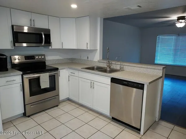 a kitchen with white cabinets stainless steel appliances and sink