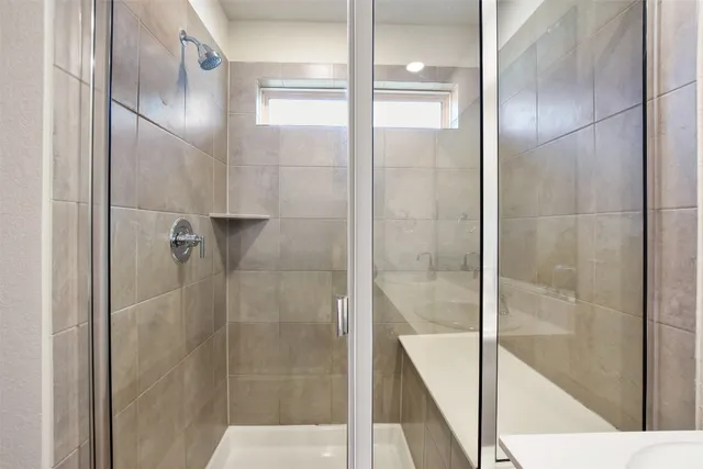 a bathroom with a shower sink and mirror