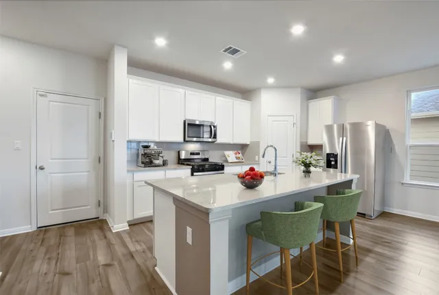 a kitchen with a sink cabinets and wooden floor