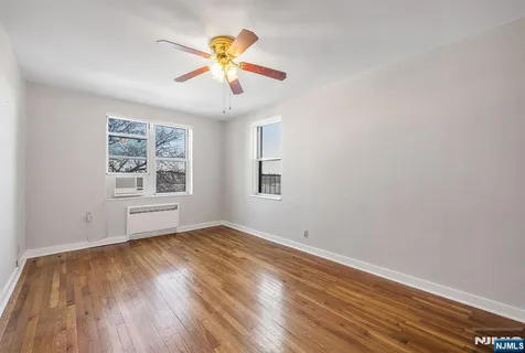 a view of room with window ceiling fan and wooden floor